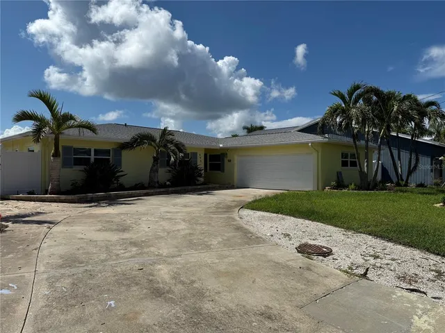 a front view of a house with a garden and trees