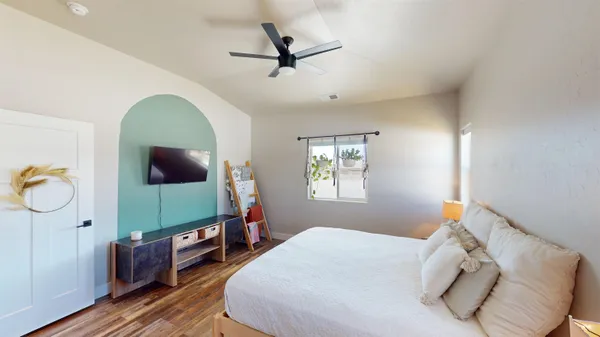 a bedroom with a bed and wooden floor