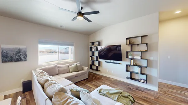 a living room with furniture and a ceiling fan