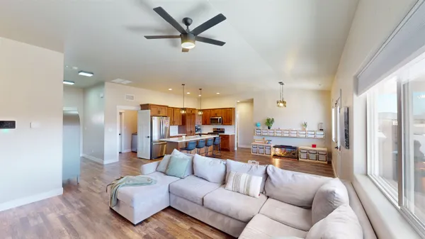 a kitchen with stainless steel appliances kitchen island granite countertop a refrigerator a sink and wooden cabinets