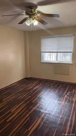 a view of a room with wooden floor and fan