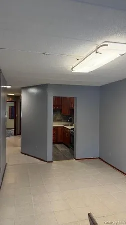 a view of an empty room and kitchen