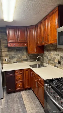 a kitchen with stainless steel appliances granite countertop wooden cabinets a stove top oven a sink and dishwasher