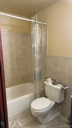 a white toilet sitting next to a bath tub and a shower