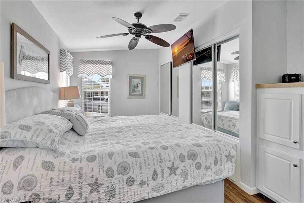 10709 Roseate Spoonbill Circle Estero, FL 33928 - Photo 13 of 32 a bedroom with a bed and wooden floor