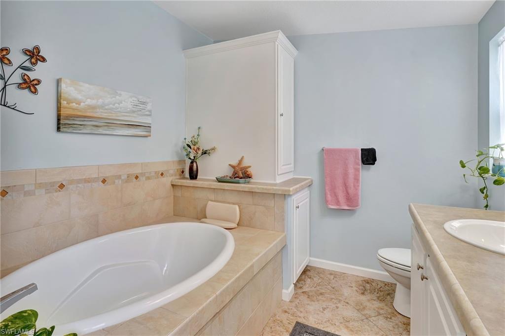 10709 Roseate Spoonbill Circle Estero, FL 33928 - Photo 15 of 32 a bathroom with a sink a toilet and a bathtub