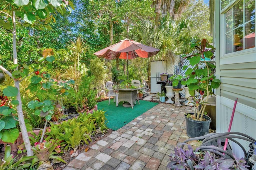 10709 Roseate Spoonbill Circle Estero, FL 33928 - Photo 23 of 32 a view of a backyard with furniture and a garden