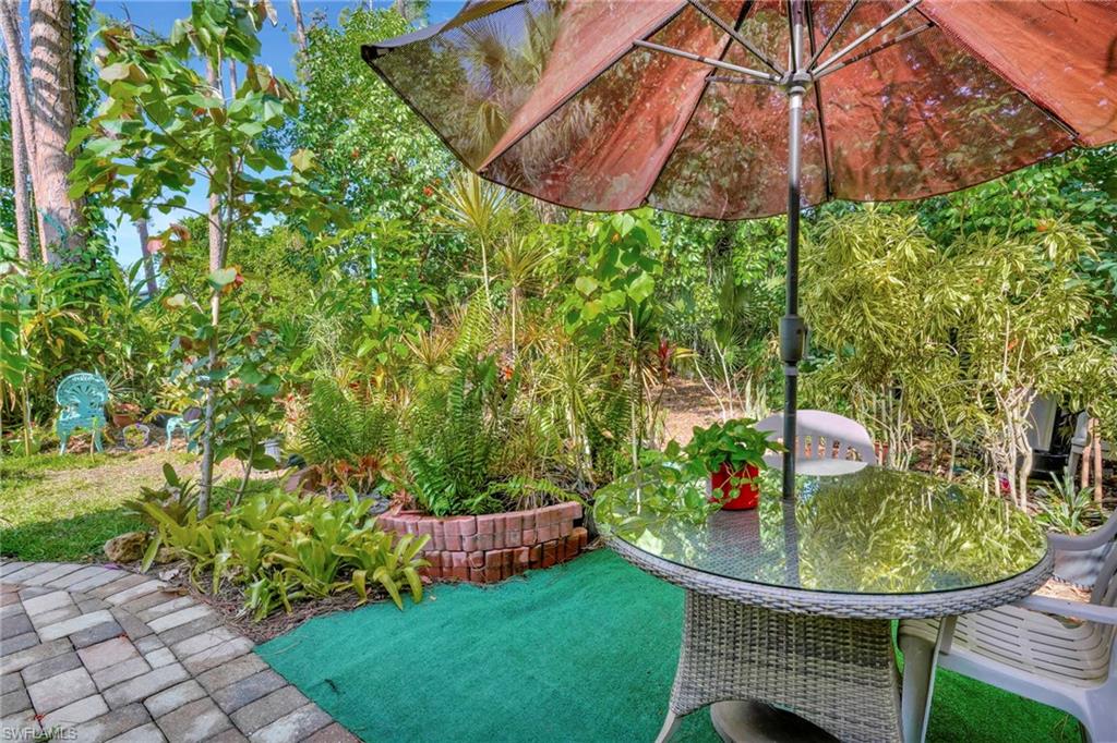 10709 Roseate Spoonbill Circle Estero, FL 33928 - Photo 24 of 32 a view of a chair and table under an umbrella