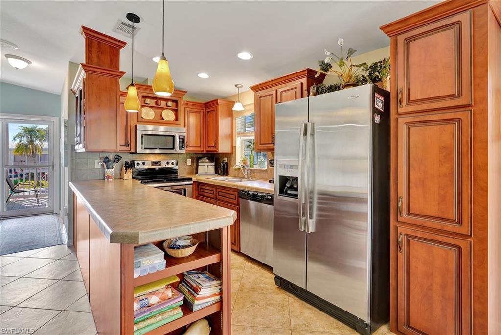 10709 Roseate Spoonbill Circle Estero, FL 33928 - Photo 7 of 32 a kitchen with stainless steel appliances granite countertop a refrigerator and a stove top oven
