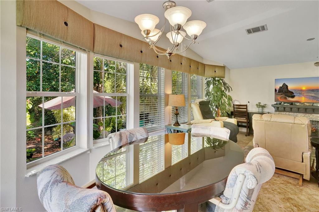 10709 Roseate Spoonbill Circle Estero, FL 33928 - Photo 8 of 32 a living room with furniture chandelier and a large window