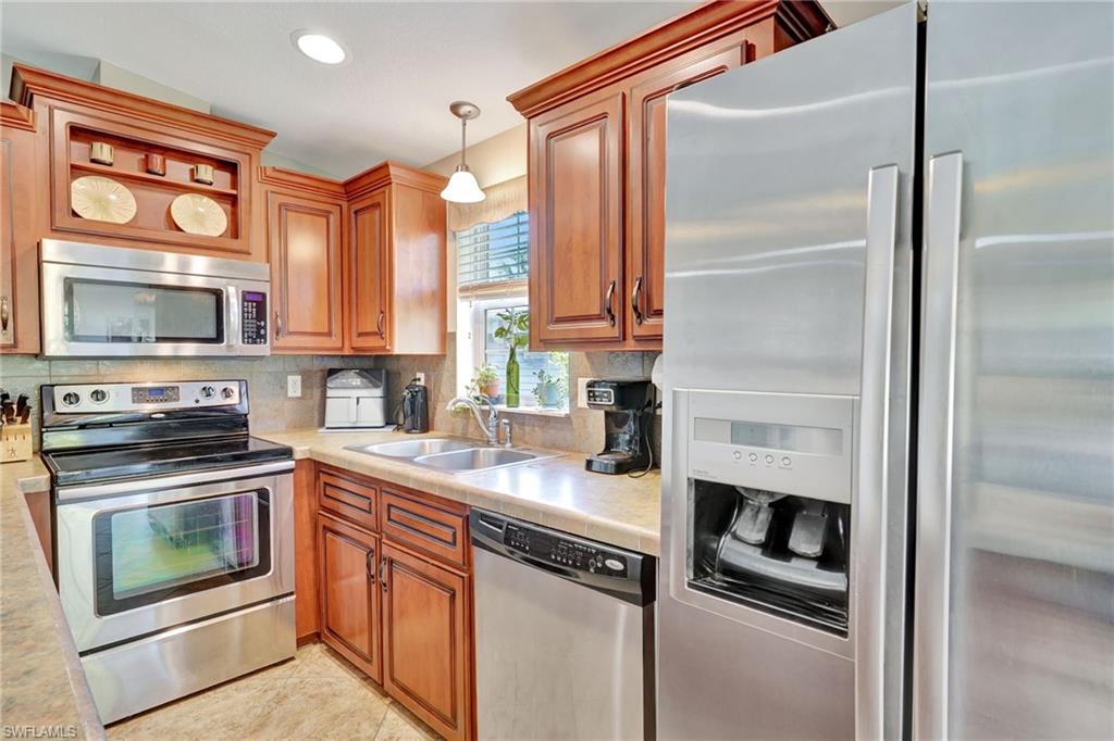 10709 Roseate Spoonbill Circle Estero, FL 33928 - Photo 10 of 32 a kitchen with stainless steel appliances granite countertop a stove top oven