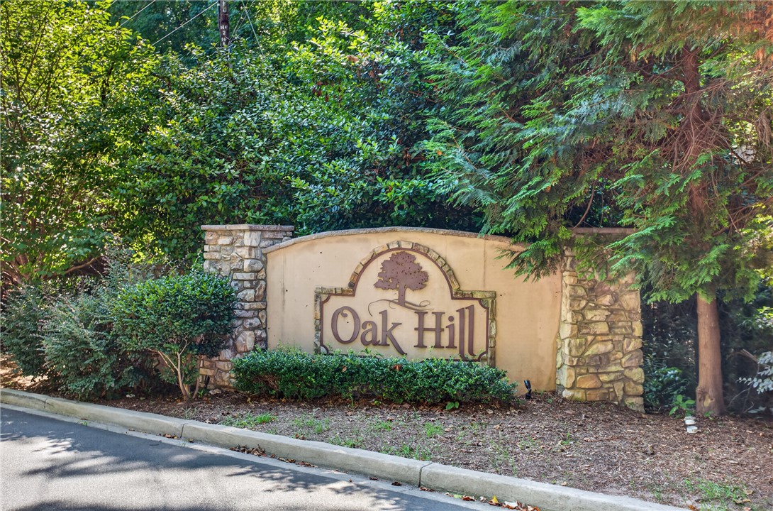 1081 Edenbrooke Circle Anderson, SC 29621 - Photo 39 of 46 Stone and stucco entry sign for the Oak Hill community, nestled amidst mature greenery.