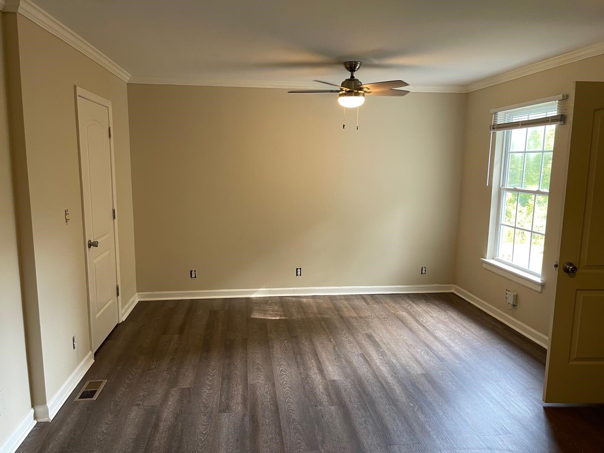 606 Infinity Road Durham, NC 27712 - Photo 5 of 30 an empty room with wooden floor fan and windows
