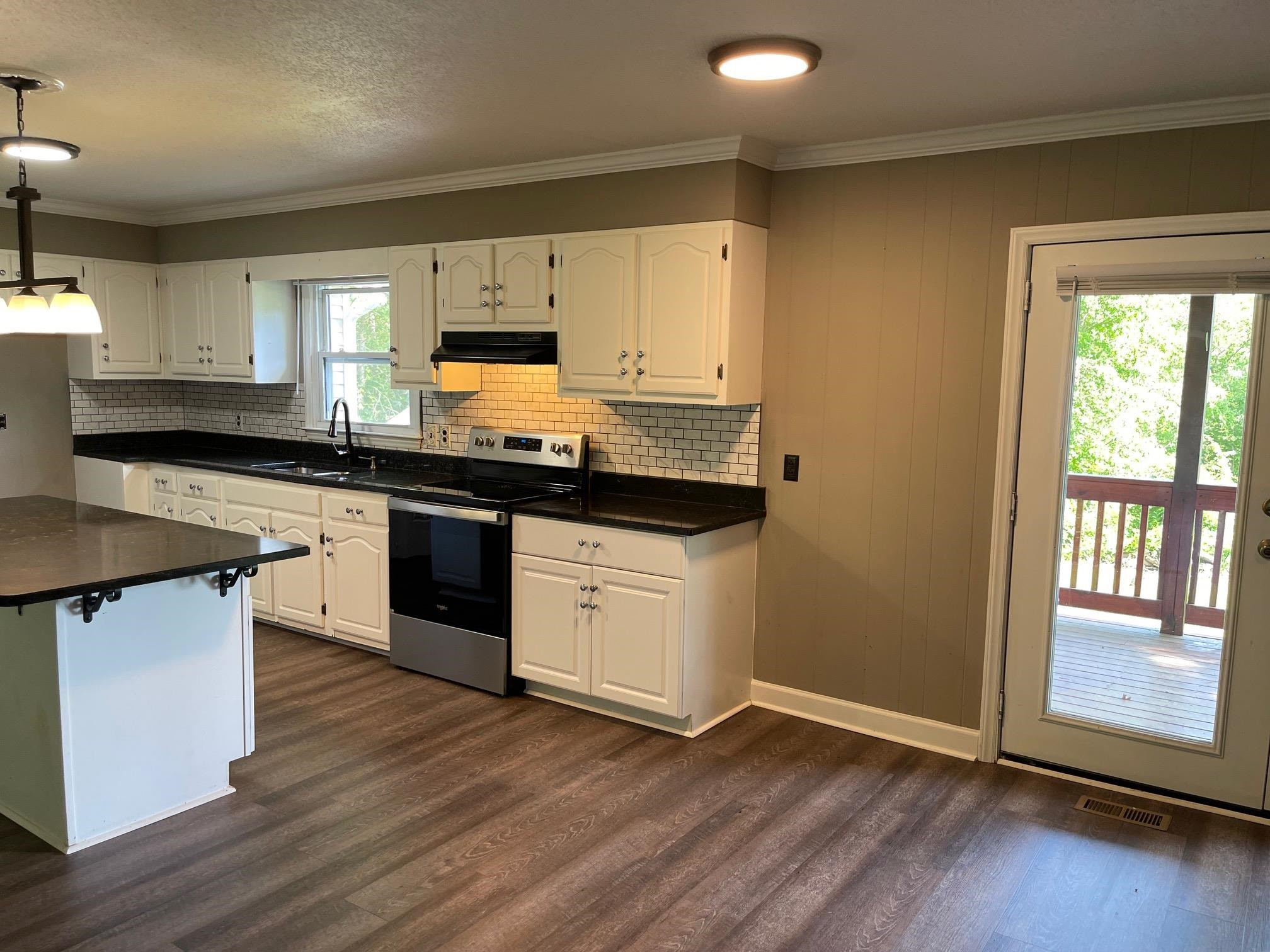 606 Infinity Road Durham, NC 27712 - Photo 9 of 30 a kitchen with granite countertop a sink cabinets and wooden floor