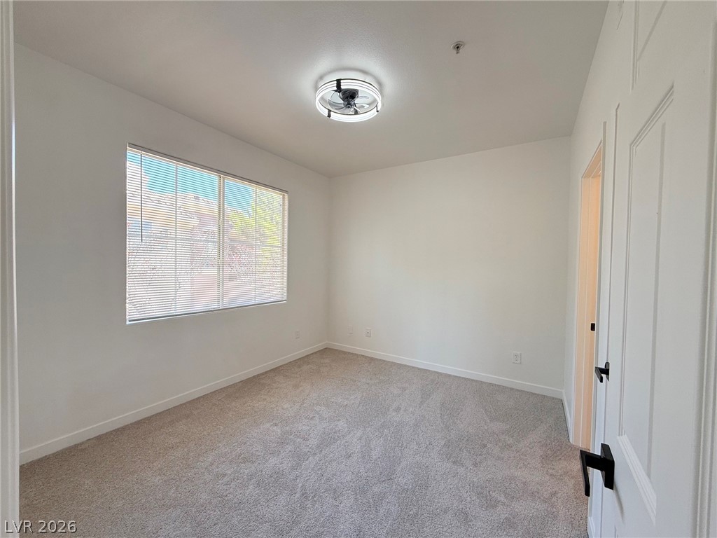 9050 West Warm Springs Road, Unit 2002 Las Vegas, NV 89148 - Photo 30 of 46 This spacious room offers comfort with soft carpeting and natural light filtering through the window.