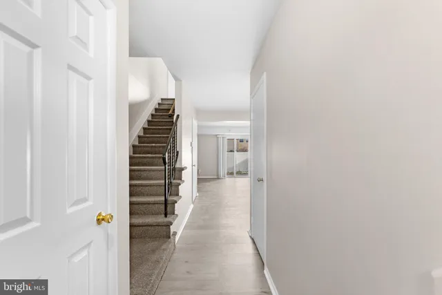 a view of a hallway with wooden floor and stairs