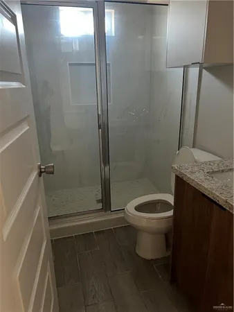a bathroom with a granite countertop toilet and a shower
