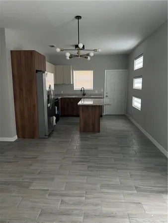 a kitchen with stainless steel appliances granite countertop a refrigerator a sink dishwasher and a stove