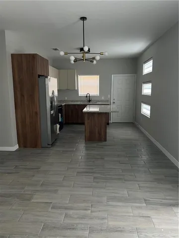 a kitchen with stainless steel appliances granite countertop a refrigerator a sink dishwasher and a stove