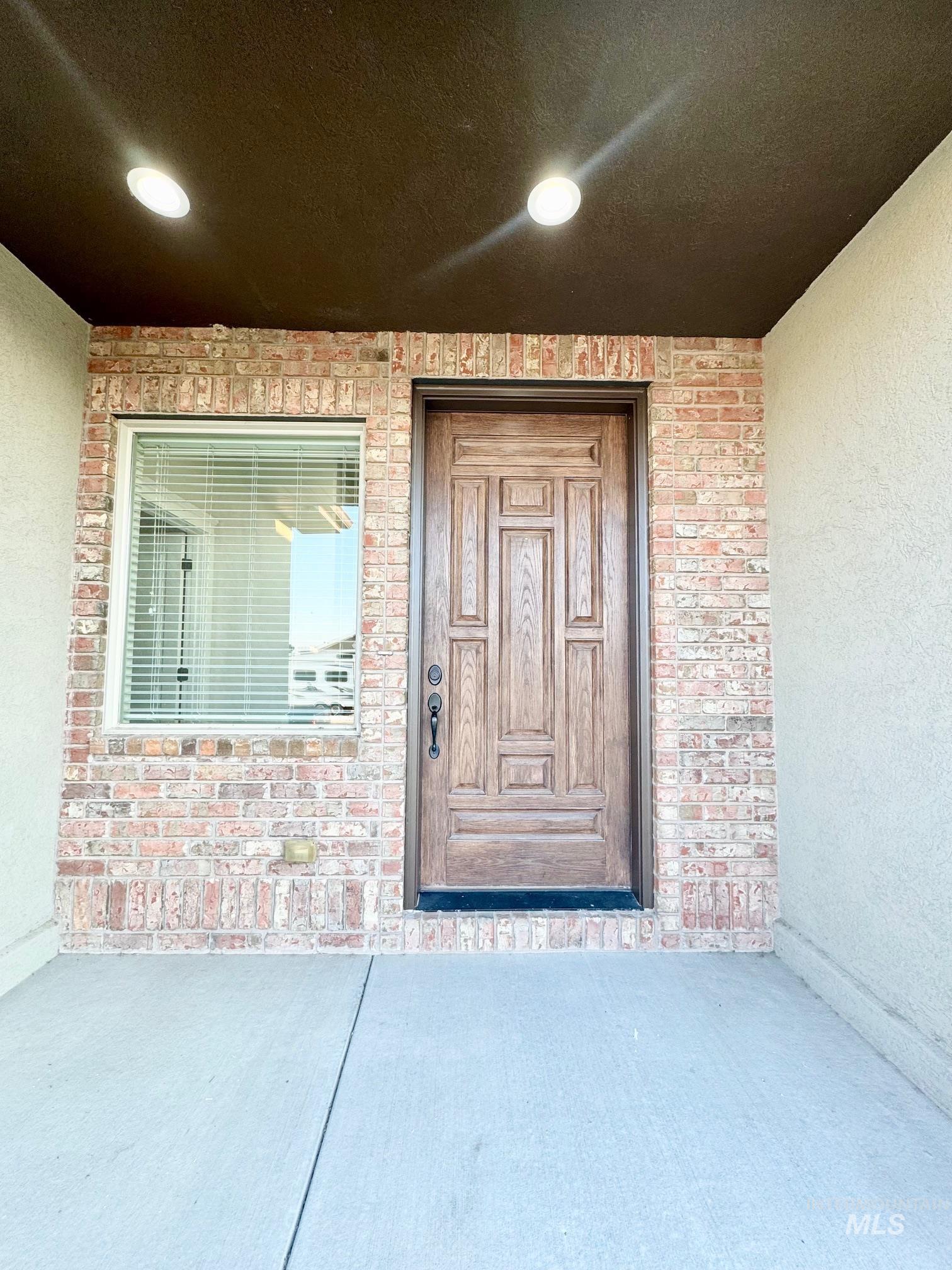 650 Lochsa Loop Heyburn, ID 83336 - Photo 2 of 26 Doorway to property featuring brick siding and stucco siding