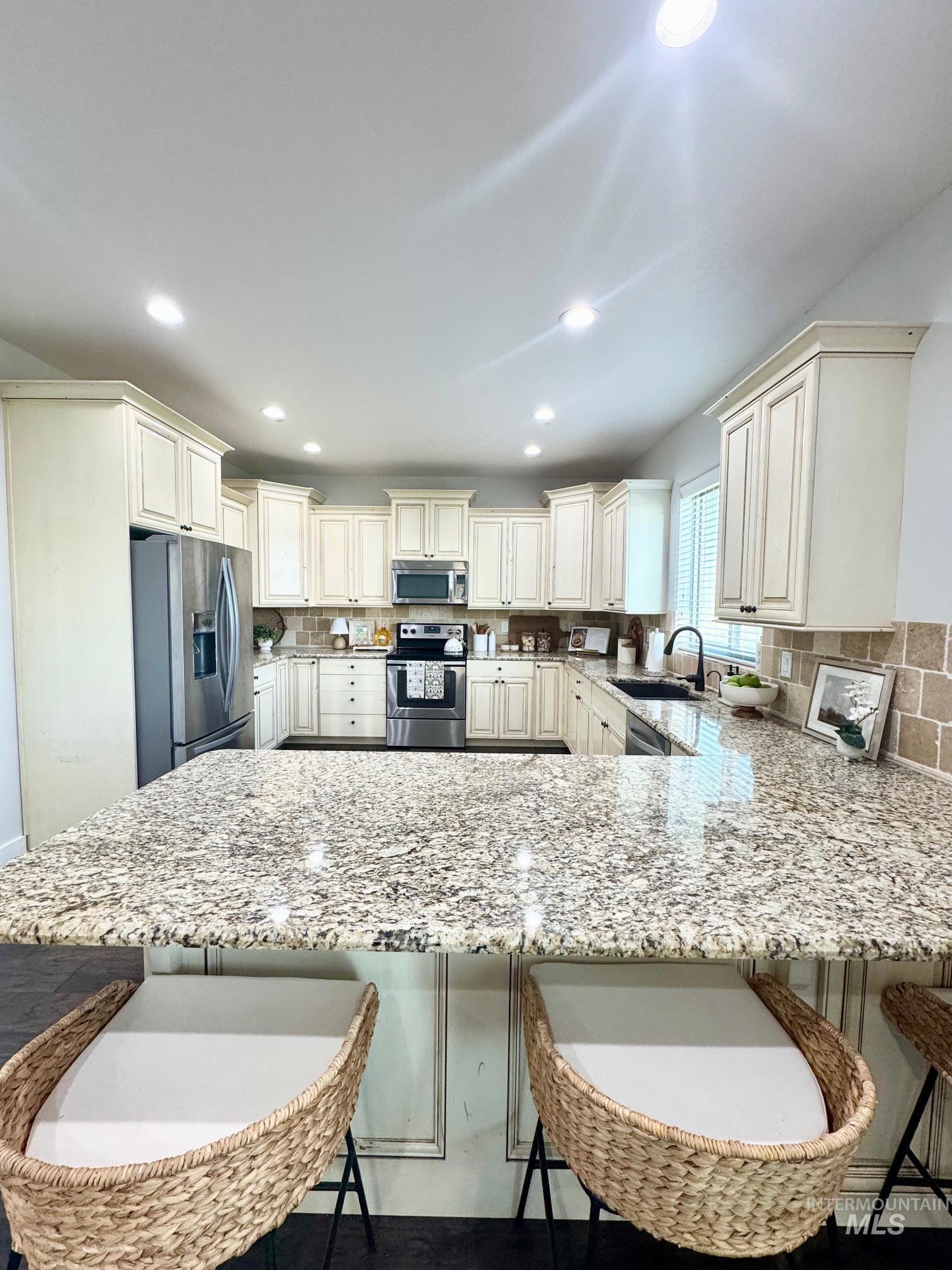 650 Lochsa Loop Heyburn, ID 83336 - Photo 8 of 26 Kitchen with a kitchen bar, light stone counters, stainless steel appliances, recessed lighting, and a peninsula