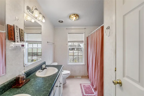 a spacious bathroom with 2 sink tub and a mirror