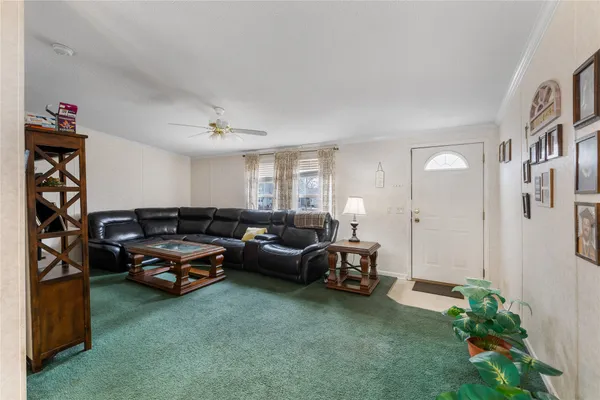 a living room with furniture a window and a potted plant