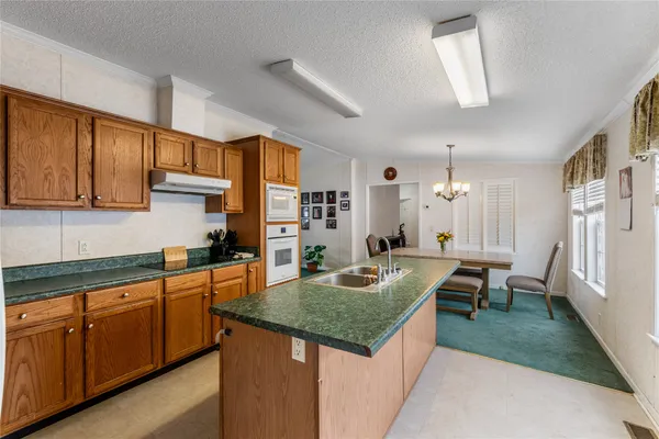 a kitchen with sink cabinets and living room view