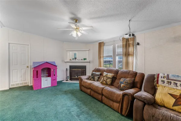 a living room with furniture a ceiling fan and a rug