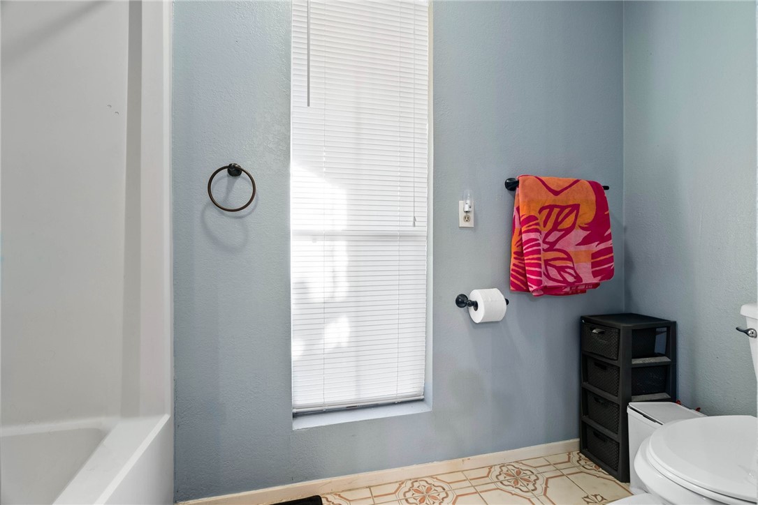 4114 Beard Drive Corpus Christi, TX 78413 - Photo 27 of 40 a bathroom with a toilet and a shower curtain