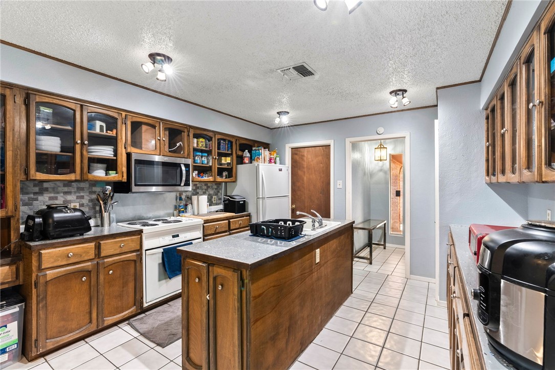 4114 Beard Drive Corpus Christi, TX 78413 - Photo 3 of 40 a kitchen with granite countertop a sink stove and cabinets