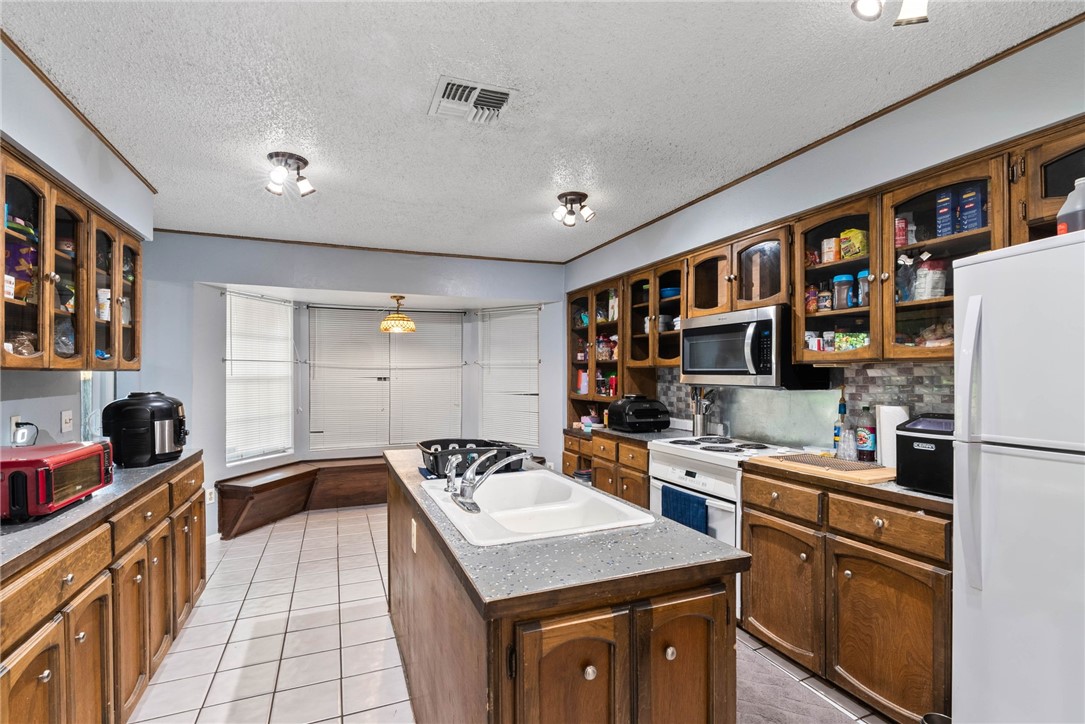 4114 Beard Drive Corpus Christi, TX 78413 - Photo 4 of 40 a kitchen that has a sink a stove and a refrigerator