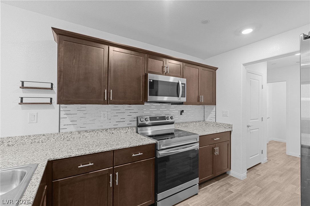 12367 Indigo Montage Road, Unit 3 Las Vegas, NV 89183 - Photo 3 of 33 This modern kitchen features rich cabinetry, sleek appliances, and elegant countertops for effortless living.