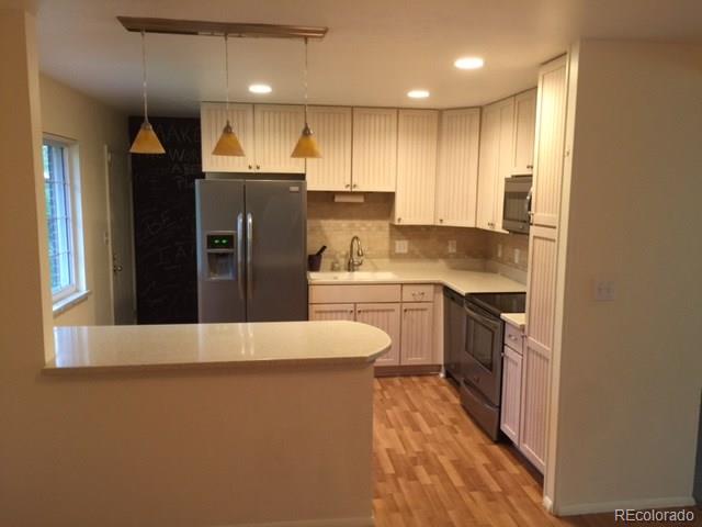529 West Ridge Road Littleton, CO 80120 - Photo 1 of 21 a kitchen with stainless steel appliances granite countertop a refrigerator a sink a stove and a refrigerator with wooden floor