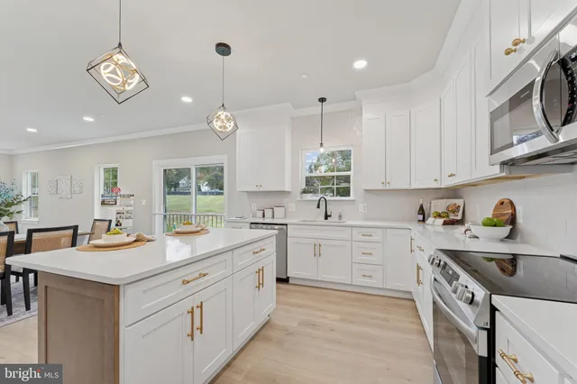 a kitchen with white cabinets appliances and a sink