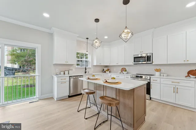 a kitchen with a stove a sink a window and cabinets