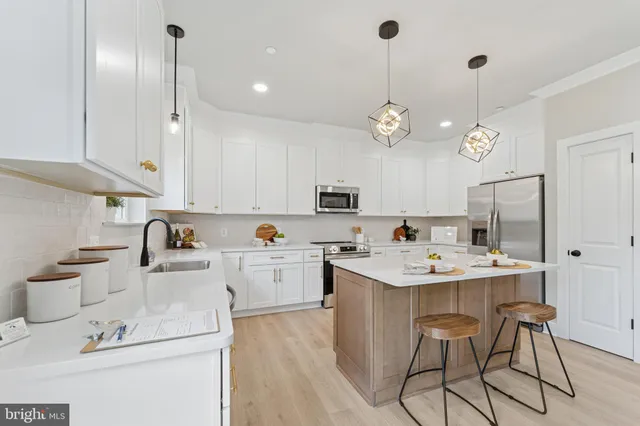 a kitchen with kitchen island a sink stove and refrigerator