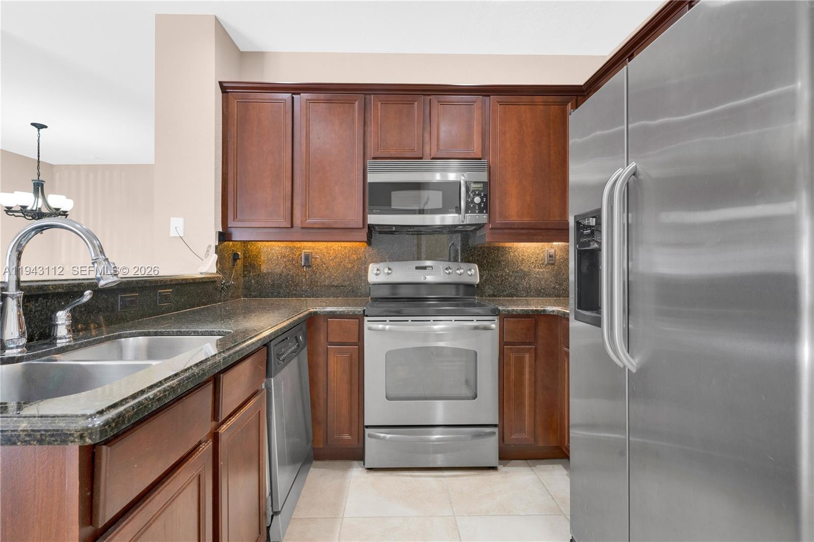 14102 Southwest 276th Street Homestead, FL 33032 - Photo 14 of 36 a kitchen with stainless steel appliances granite countertop a sink stove and refrigerator