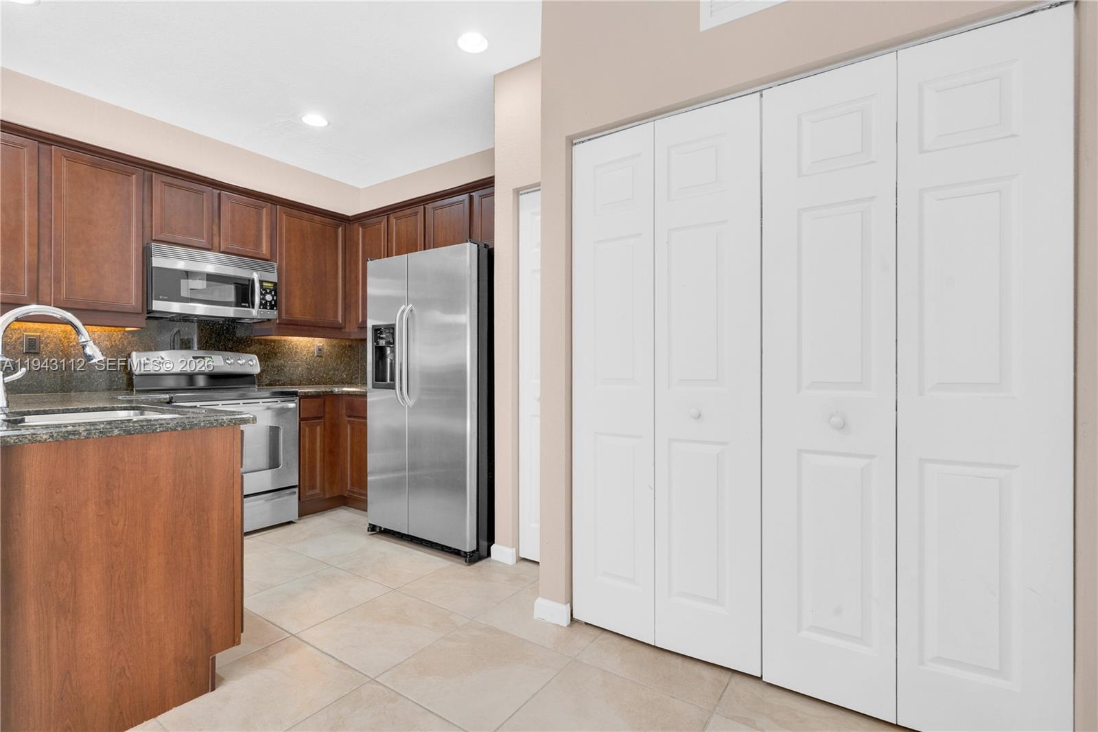 14102 Southwest 276th Street Homestead, FL 33032 - Photo 17 of 36 a kitchen with stainless steel appliances granite countertop a refrigerator stove and a sink
