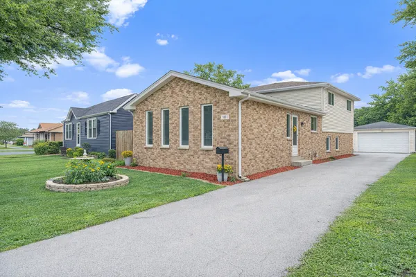a front view of a house with a garden and yard