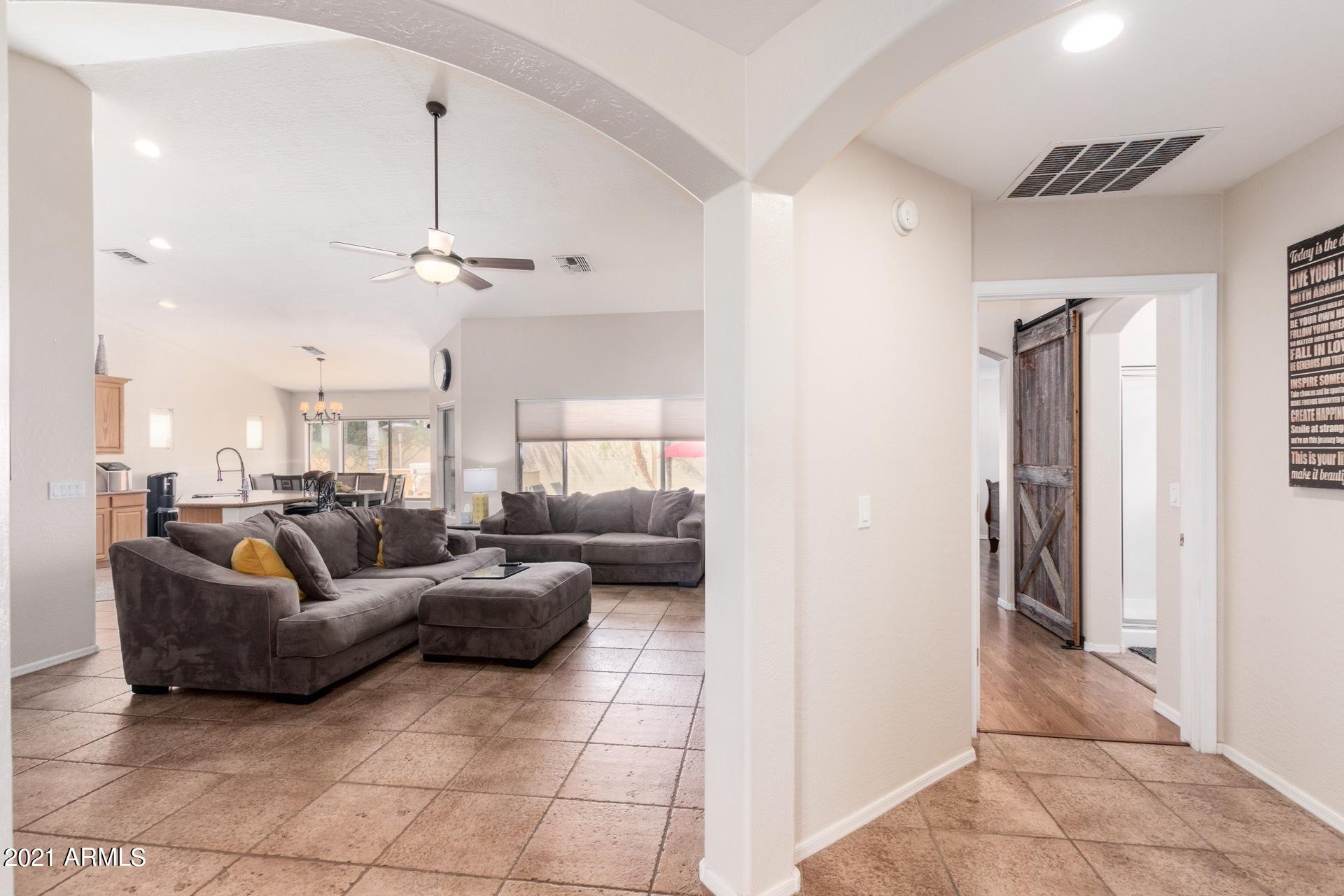 3124 South Martingale Road Gilbert, AZ 85295 - Photo 3 of 26 a living room with furniture and a chandelier