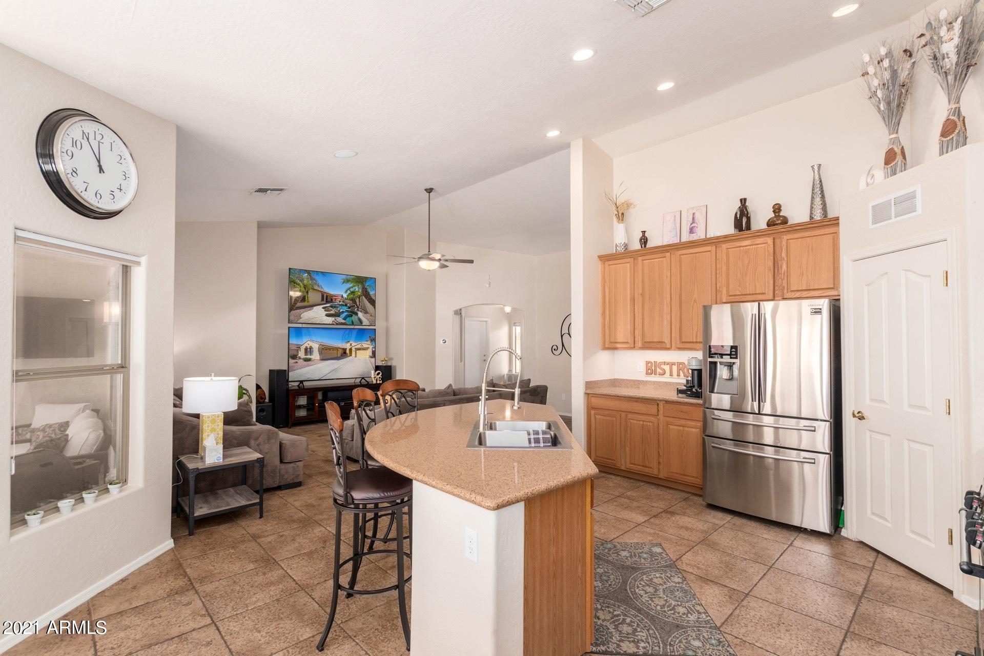3124 South Martingale Road Gilbert, AZ 85295 - Photo 9 of 26 a kitchen with refrigerator and chairs