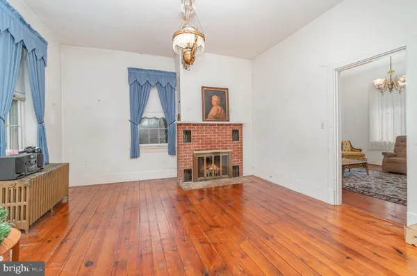 a view of empty room with wooden floor and window