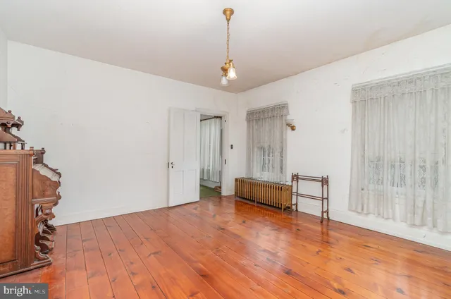 a view of a room with wooden floor and furniture