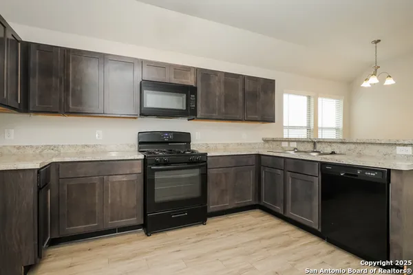 a kitchen with granite countertop wooden cabinets and stainless steel appliances