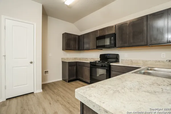 a kitchen with stainless steel appliances granite countertop a stove a sink and a microwave
