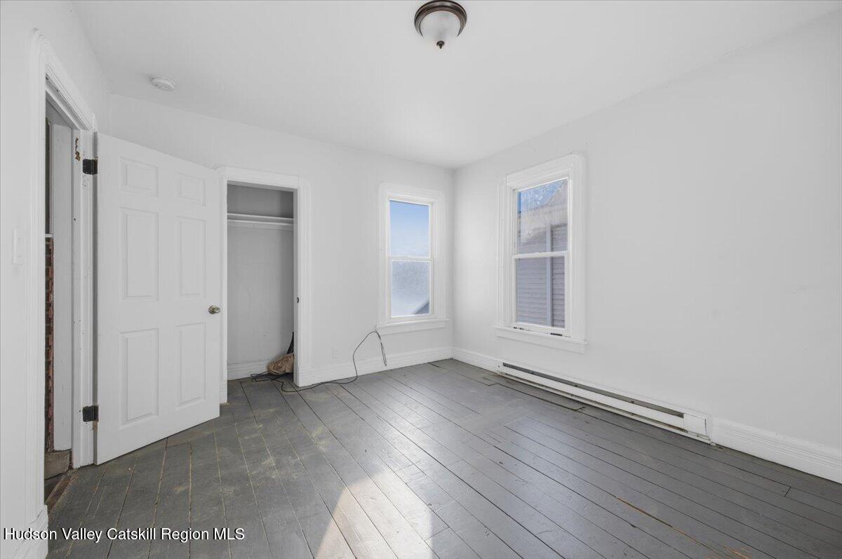 97 Maple Avenue Catskill, NY 12414 - Photo 11 of 27 a view of an empty room with wooden floor and a window