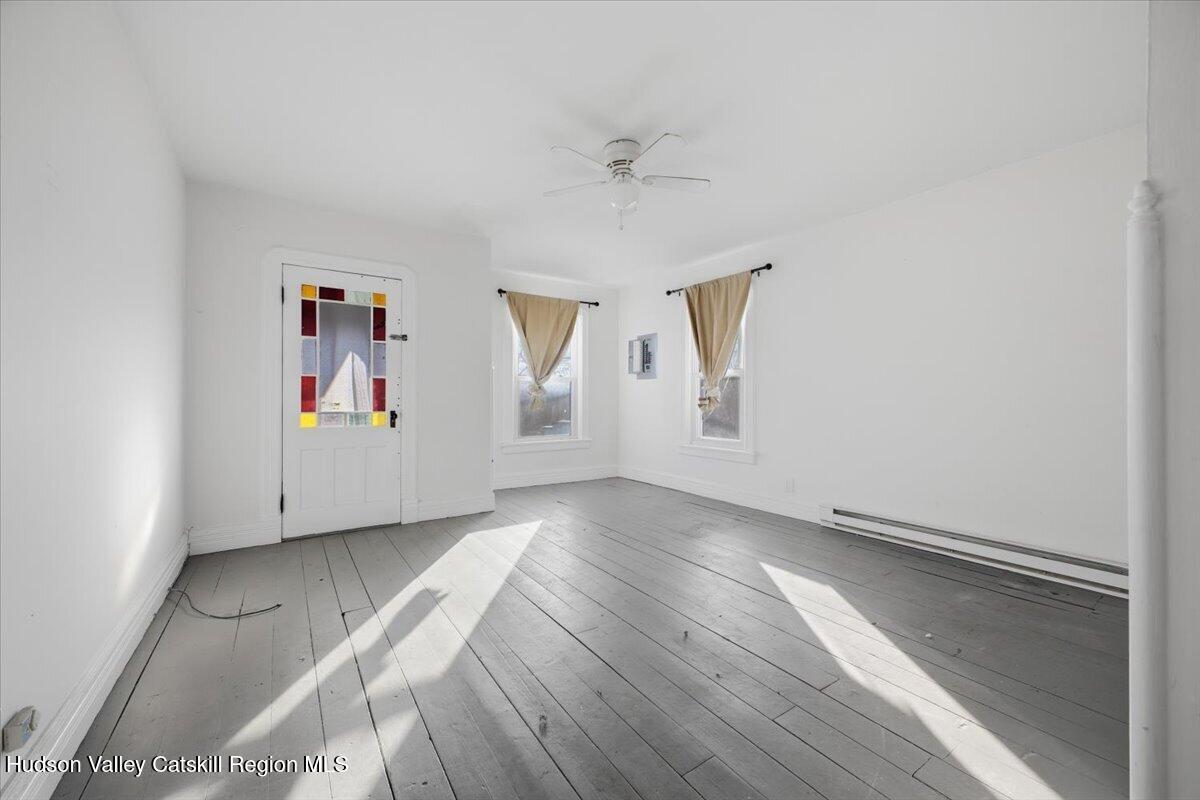 97 Maple Avenue Catskill, NY 12414 - Photo 7 of 27 an empty room with wooden floor and window
