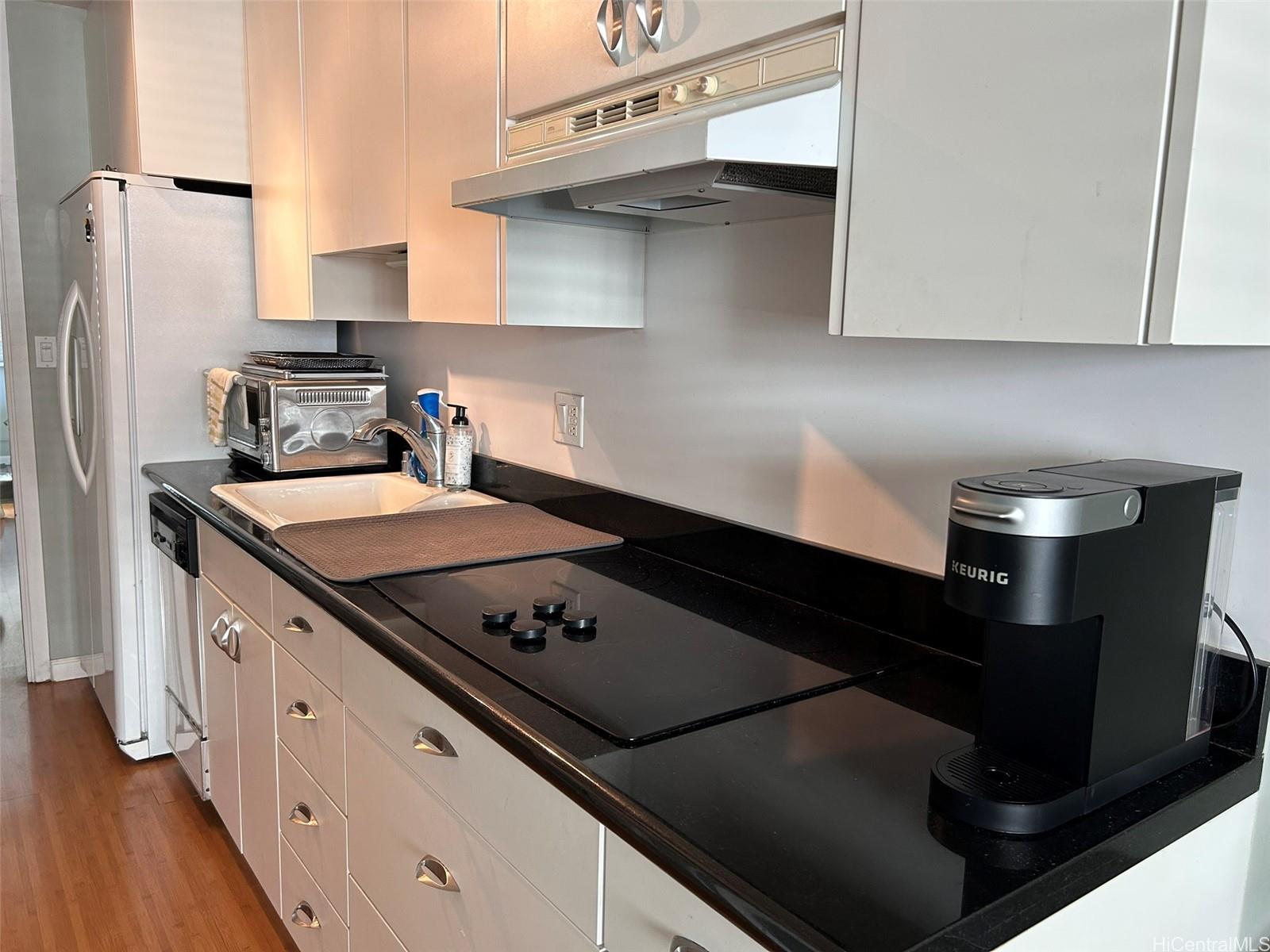 425 Ena Road, Unit 1208A Honolulu, HI 96815 - Photo 6 of 21 a kitchen with stainless steel appliances a sink stove and refrigerator