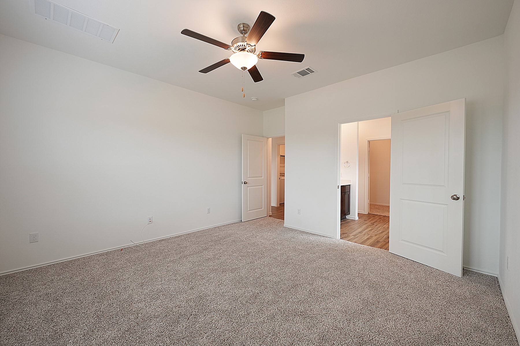 932 Mallow Road Leander, TX 78641 - Photo 15 of 34 A spacious bedroom offers comfort with a ceiling fan for climate control and plush carpeting underfoot.